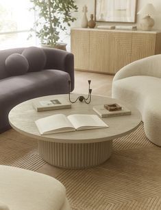 a living room filled with furniture and a book on top of a table in front of two couches