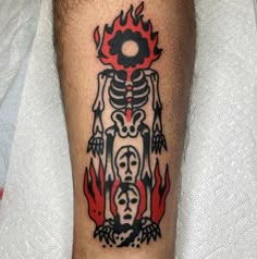 a man's leg with a skeleton and flames tattoo design on the calf area