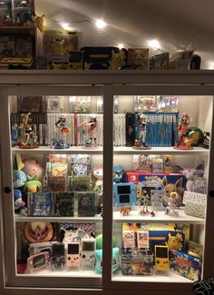 a display case filled with lots of toys and other items on top of glass doors