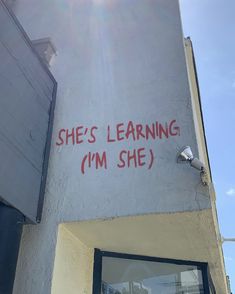 graffiti on the side of a building that says she's learning i'm she