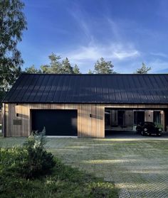 the house is made out of wood and has two garages on one side, while another