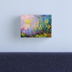 an abstract painting of flowers and grass on a blue background canvas mounted to a wall