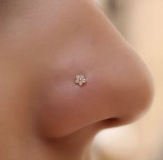 a close up view of a nose with a tiny flower on it