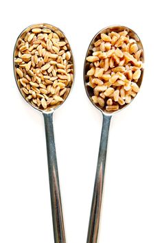 two spoons filled with nuts sitting next to each other