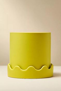 a yellow bowl sitting on top of a white table