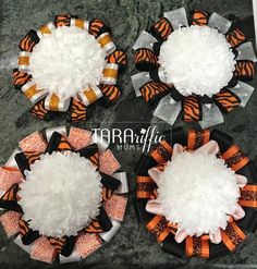 three plates with orange and black hair bows on them, one has white fluffy balls in the center