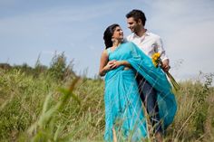 a man and woman standing in tall grass