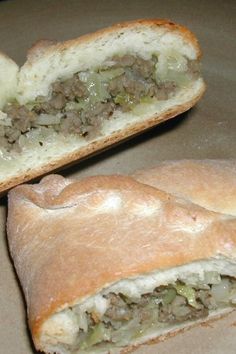 two pieces of bread with meat and cheese in it sitting on a plate next to each other