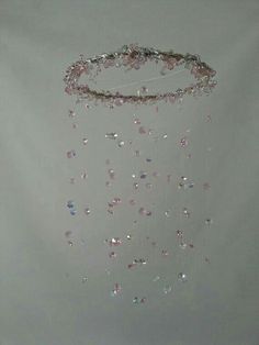 a white wall with some pink and silver beads hanging from it's side,