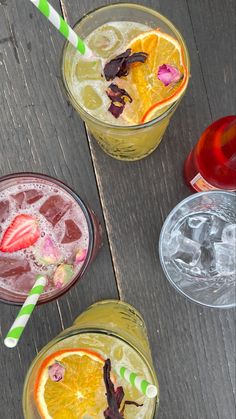 three glasses filled with different types of drinks on top of a wooden table next to each other