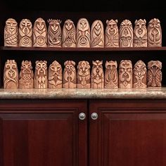 wooden carvings are on display in a cabinet