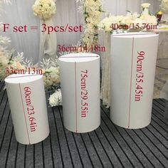 three tall white vases sitting on top of a table