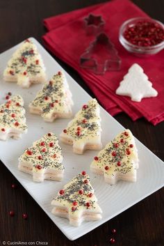 small christmas trees on a white plate with red and black sprinkles around them