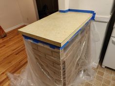 a kitchen counter being constructed with plywood and plastic wrapped around the top to protect it from damage