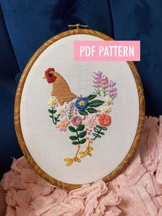 a close up of a embroidery on a piece of cloth with flowers and a rooster