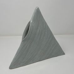 a gray vase with a triangle shaped design on it