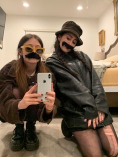 two people with fake moustaches on their faces are taking a selfie