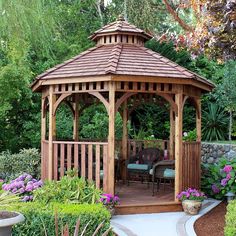 a wooden gazebo sitting in the middle of a garden