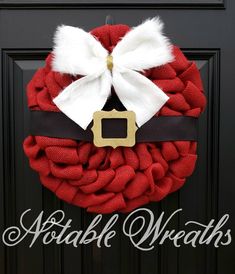 a red wreath with white and black ribbon on it