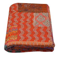 an orange and red quilted blanket on top of a white surface with the words neha enterprises