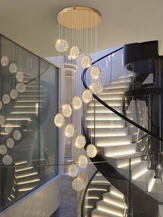 a spiral staircase with chandelier hanging from it's sides and lights on either side