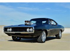 an old muscle car is parked in a parking lot