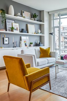 a living room filled with furniture and a large window covered in lots of natural light