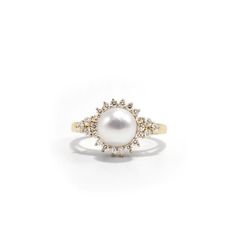 a pearl and diamond ring on a white background