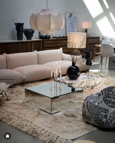 a living room filled with lots of furniture and decor on top of a shaggy rug