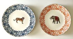 two plates with animals painted on them, one is orange and the other is blue