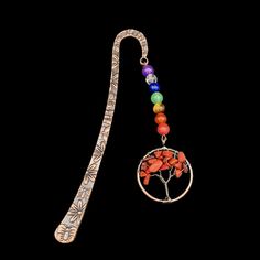 a tree of life pendant with seven chakra beads on a black background stock photo