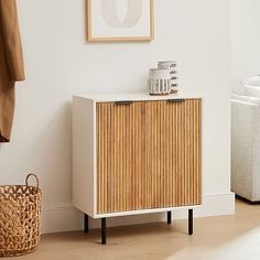 a wooden cabinet sitting next to a white couch in a living room on top of a hard wood floor