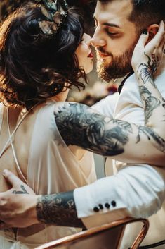 a tattooed man and woman kissing each other