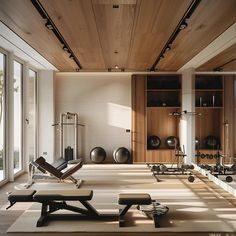 an empty gym with lots of machines and exercise mats on the floor in front of large windows