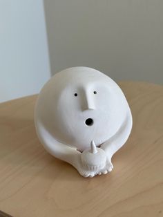 a white ceramic animal sitting on top of a wooden table