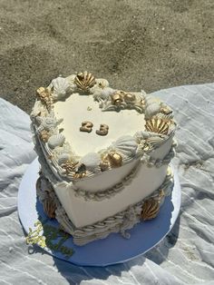 a heart shaped cake sitting on top of a blue plate covered in seashells