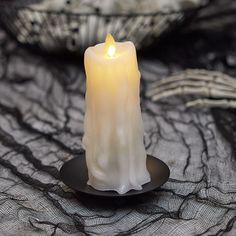 a lit candle sitting on top of a black plate