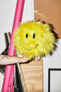 a yellow smiley face stuffed animal sitting on top of a pink bike handlebars