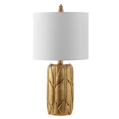 a gold table lamp with a white shade on the top and an intricately designed base