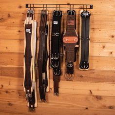 several different types of belts hanging on a wall