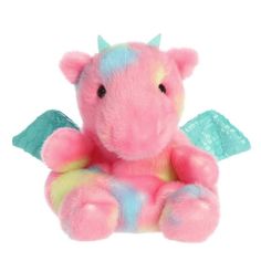 a pink and blue stuffed animal sitting on top of a white surface with wings around it's neck