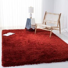 a living room with a red rug and chair