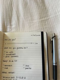 an open notebook with writing on it next to a pen