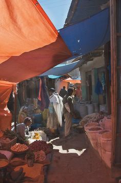 an outdoor market with people shopping and selling goods