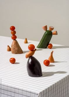 an assortment of fruits and vegetables sitting on top of a white tablecloth covered table