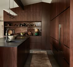 a kitchen with dark wood cabinets and an area rug