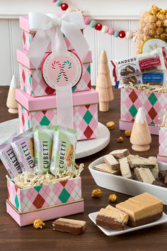 a table topped with boxes filled with treats and candy bar containers covered in candies