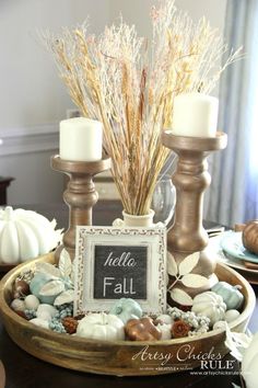 a tray with candles and some flowers in it on top of a table next to a chalkboard sign that says hello fall