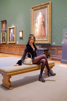 a woman sitting on a bench in a museum