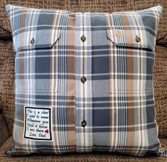 a plaid pillow with a patch on the side and a buttoned down pocket at the back